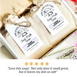 May include: Two bars of goat milk soap wrapped in beige fabric and tied with twine, each featuring a white tag labelled One Blessed Acre Farm, Fresh Lavender, and Net Wt 127g. The bars are presented inside a white cardboard box.