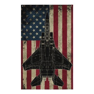 May include: A black silhouette of an F-15 Eagle fighter jet against a distressed American flag background.