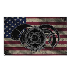 May include: A distressed American flag with a black and white illustration of a jet engine. The flag features red and white stripes and a blue field with white stars. The jet engine is centered on the flag.