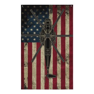 May include: A black silhouette of a helicopter superimposed on a distressed American flag. The flag has red and white stripes and blue stars.