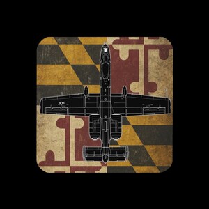 K&ouml;nnte beinhalten: Eine schwarze Umrisszeichnung eines A-10 Thunderbolt II-Flugzeugs ist auf einem quadratischen Hintergrund zentriert. Der Hintergrund zeigt das Design der Flagge des Bundesstaates Maryland in einem Used-Look mit schwarzem Rand.