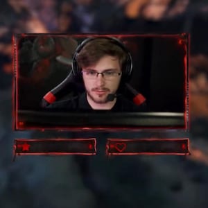 May include: A live streaming overlay featuring a person wearing a headset and glasses. The overlay has a red border and two red boxes with icons. The background is blurred.