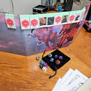 May include: A tabletop game set with a fantasy-themed map, dice, and character cards. The map features a red dragon flying over a volcanic island. The character cards are labeled with names like "Bo", "Ava", and "Lenny".