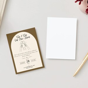 Puede incluir: Tarjeta de invitaci&oacute;n marr&oacute;n con el texto "Sip & See Our New Home" en un arco decorativo. Tambi&eacute;n hay una tarjeta blanca en blanco y un bol&iacute;grafo dorado. Invitaci&oacute;n para una fiesta de inauguraci&oacute;n.