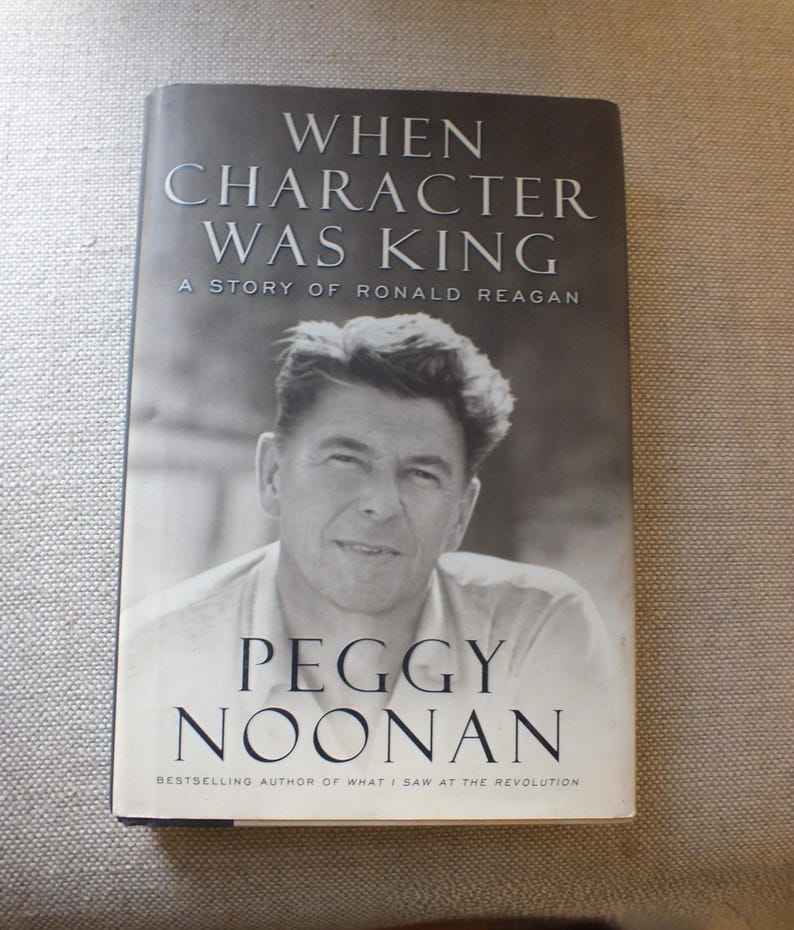 Puede incluir: Un libro titulado "When Character Was King: A Story of Ronald Reagan" de Peggy Noonan. La portada presenta un retrato en blanco y negro de Ronald Reagan. El nombre de la autora est&aacute; en negrita.