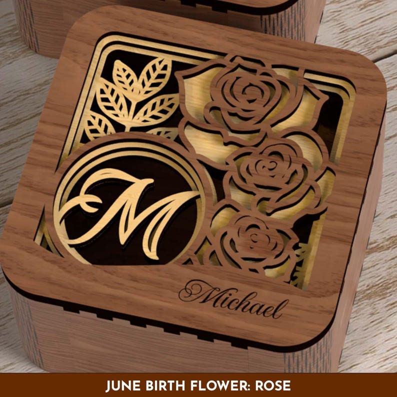 May include: Wooden box with a laser-cut design featuring roses and leaves. The box has a gold-colored interior and a circular monogram with the letter "M". The name "Michael" is engraved on the box. The text "JUNE BIRTH FLOWER: ROSE" is at the bottom.