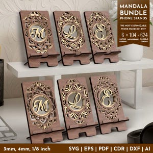 May include: Wooden phone stands with mandala designs and monogram letters. The stands are brown with gold accents and feature the letters M, L, and E. The text on the image says "Mandala Bundle Phone Stands" and "6 x 104-624 possible combos".