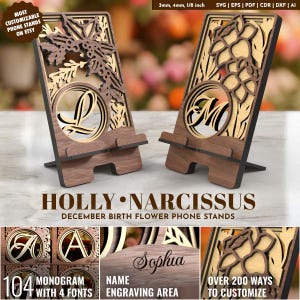 May include: Two wooden phone stands with floral and monogram designs. The stands are brown with a lighter wood accent. The text "HOLLY • NARCISSUS" and "DECEMBER BIRTH FLOWER PHONE STANDS" are visible. The stands are customizable.