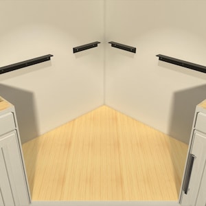 May include: A corner kitchen cabinet setup with white cabinets, black hardware, and wooden interiors. Black metal shelf brackets are mounted on the walls. The floor is light wood.