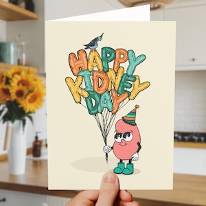May include: Greeting card with the text "HAPPY KIDNEY DAY" in colorful balloon letters. A cartoon kidney character wearing a party hat and boots holds the balloons. A small bird sits atop the text.