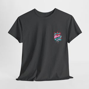 Puede incluir: Una camiseta gris oscuro con un gr&aacute;fico de un coraz&oacute;n rosa envuelto en una serpiente azul con llamas rojas sobre un fondo negro.