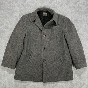 May include: A gray wool coat featuring a notched collar, three brown buttons down the front, and two side pockets. The interior is lined with black quilted fabric and includes a Pendleton brand label at the neck. The coat has long sleeves.