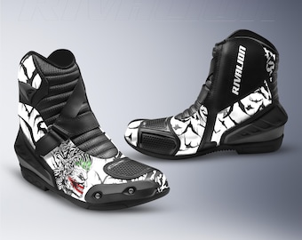 Könnte beinhalten: Paar schwarz-weiße Motorradstiefel mit einem Joker-Motiv. Die Stiefel haben ein hohes Design mit Schnallenverschluss und dem Wort "RIVALION" auf der Seite. Die Stiefel haben eine schwarze Sohle.