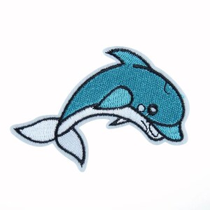 May include: An iron-on patch featuring a cartoon dolphin jumping out of the water, embroidered in blue and white.
