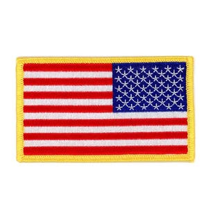 May include: An embroidered patch with a yellow border, depicting the American flag. The flag is red, white and blue with 13 horizontal stripes and 50 white stars on a blue field.