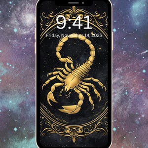 May include: A smartphone displays a gold scorpion design on a black background, framed by ornate gold accents. The time 9:41 and the date Friday, November 14, 2025, are visible at the top. The background features a cosmic, starry pattern.