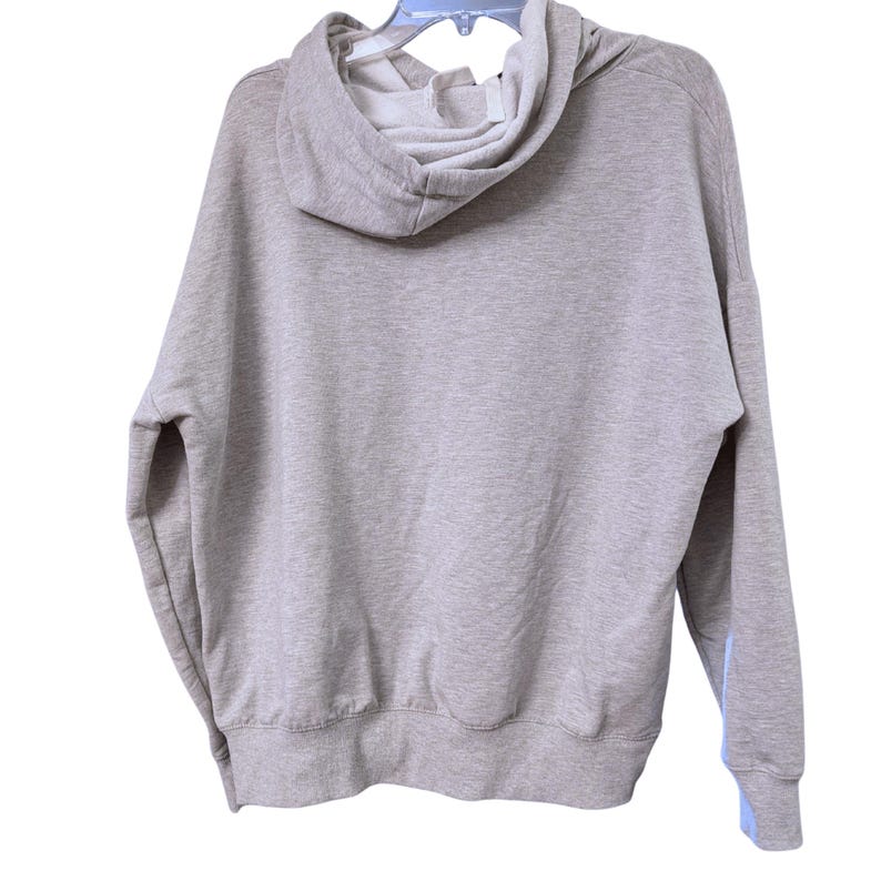 May include: A light gray hoodie with a drawstring hood and long sleeves. The hoodie is hanging on a clear plastic hanger. The interior of the hood is white, and there is a light blue accent on the sleeve.