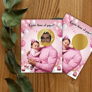 Puede incluir: Dos tarjetas rosas para un juego de baby shower con el texto "Quien tiene al papa?" y un círculo dorado para una cara. Una tarjeta muestra a un bebé y a un hombre con una camisa rosa. El fondo tiene globos rosas y blancos y cupcakes.