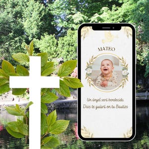 May include: A white cross with green foliage in front of a smartphone displaying a baptism invitation. The invitation features a photo of a baby, the name "MATEO", and Spanish text.