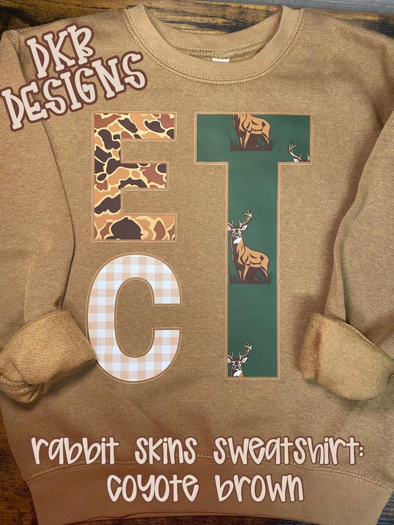 Puede incluir: Sudadera marr&oacute;n coyote con las letras "ETC". La "E" tiene un patr&oacute;n de camuflaje, la "T" un gr&aacute;fico de ciervo y la "C" un dise&ntilde;o de cuadros. Tambi&eacute;n se ve el texto "DKR DESIGNS" y "rabbit skins sweatshirt: coyote brown".