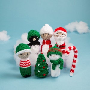 May include: A set of knitted Christmas ornaments, including a snowman, Santa Claus, a penguin, an elf, a Christmas tree, and a candy cane. The ornaments are all white, red, and green.