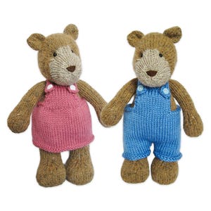 Peut inclure: Deux ours en peluche tricotés avec une fourrure brune et un museau beige clair. L'ours de gauche porte une robe tricotée rose avec des boutons blancs sur les bretelles. L'ours de droite porte une salopette tricotée bleue avec des boutons blancs.
