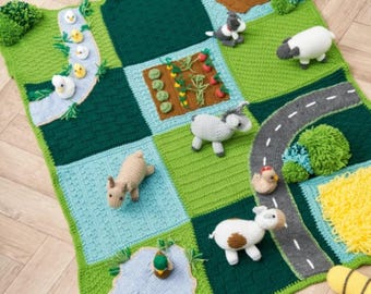 Puede incluir: Una alfombra de juego de ganchillo multicolor con temática de granja y varios cuadrados texturizados. La manta incluye animales de ganchillo tridimensionales como un cerdo, una oveja, un burro y patos, junto a un huerto, un camino y un estanque.