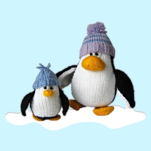 Puede incluir: Dos figuras de pingüinos de punto, una grande y otra pequeña, sobre una nube blanca contra un fondo azul claro. Los pingüinos tienen cuerpos blancos, alas negras y picos y patas naranjas. Ambos llevan gorros de punto azules con pompones.