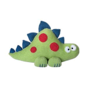 May include: A knitted green dinosaur-shaped cushion with blue spikes and red spots. The dinosaur has white eyes and blue feet. This soft toy is designed for children.