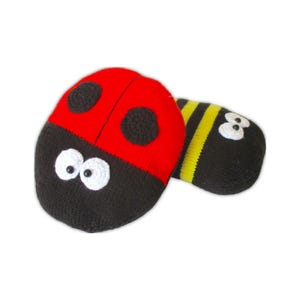 Puede incluir: Dos juguetes de insectos tejidos. Uno es una mariquita con la parte superior roja, lunares negros y la parte inferior negra con ojos blancos. El otro es una abeja con rayas negras y amarillas y ojos blancos.