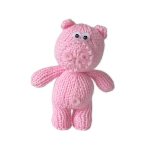 May include: A handmade pink knitted pig toy with googly eyes. The pig has a round body, small arms and legs, and a curly tail. The pig's snout is detailed with a stitched design. This soft toy is perfect for children.