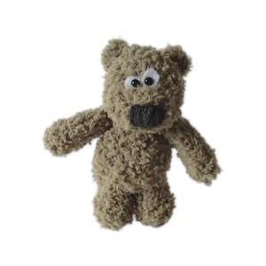 May include: A small, plush teddy bear in a light brown color. The bear has a textured, fuzzy appearance, with white and black eyes and a dark gray nose. Its arms and legs are outstretched, giving it a friendly look.
