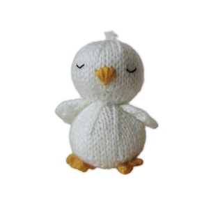 May include: A handmade, knitted white chick with a yellow beak and feet. The chick has closed eyes and small wings. This soft, plush toy is a charming addition to any nursery or a delightful gift for a child.