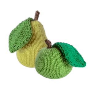Op de afbeelding: Twee gebreide fruitspeeltjes: een gele peer en een groene appel. De peer heeft een bruine steel en een groen blad. De appel heeft ook een bruine steel en een groen blad. Beide zijn gemaakt van garen.