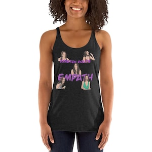 May include: Dark gray tank top with a graphic design featuring the text "EMPATH" in purple, along with illustrations of a woman. The top has a scoop neck and is sleeveless.