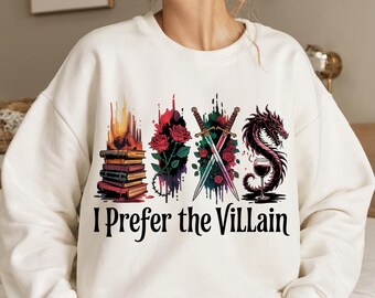 May include: White sweatshirt with a graphic print of a stack of books, two swords crossed, a dragon, and a glass of wine. The text "I Prefer the Villain" is printed below the graphic.