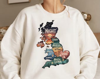 May include: White sweatshirt with a colorful graphic of a map of the United Kingdom. The map is divided into sections with different names, including "Night", "Dawn", "Day", "Under the Mountain", "Winter", "Autumn", "Spring", "Summer", and "Mortal Launbn".