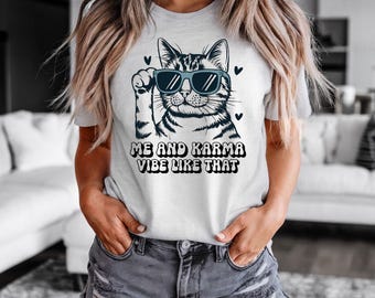 May include: White t-shirt with a cartoon cat wearing sunglasses and the text "Me and Karma Vibe Like That".