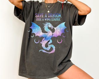 May include: A charcoal gray oversized t-shirt with a graphic print of a purple and blue dragon with galaxy wings. The text "Save a dragon, ride a wing leader." is printed on the shirt.