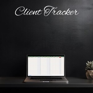 May include: A laptop computer with a spreadsheet open on the screen, labeled "Client Tracker". The laptop is on a black desk with a stack of notebooks and a potted succulent plant.