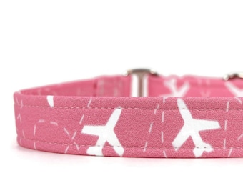 Peut inclure: Un collier pour chien rose avec un motif d'avion blanc.