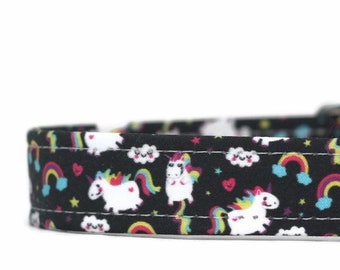 May include: Black dog collar with a colorful unicorn and rainbow print. The collar has a black buckle and the text "collarshop" is visible on the right side.