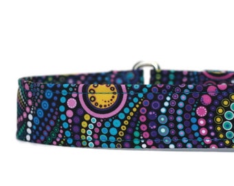 May include: A black dog collar with a colorful pattern of circles and dots in shades of pink, blue, green, and yellow.