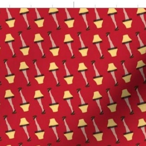 May include: A red fabric with a repeating pattern of yellow lampshades with legs and black shoes. The lampshades are in the shape of a traditional table lamp with a white lightbulb.