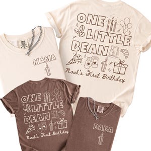 May include: A collection of four t-shirts in cream and brown colors. Two shirts feature the text MAMA or DADA with a number one candle. Two shirts feature the text ONE LITTLE BEAN and Noah's First Birthday with coffee and party graphics.