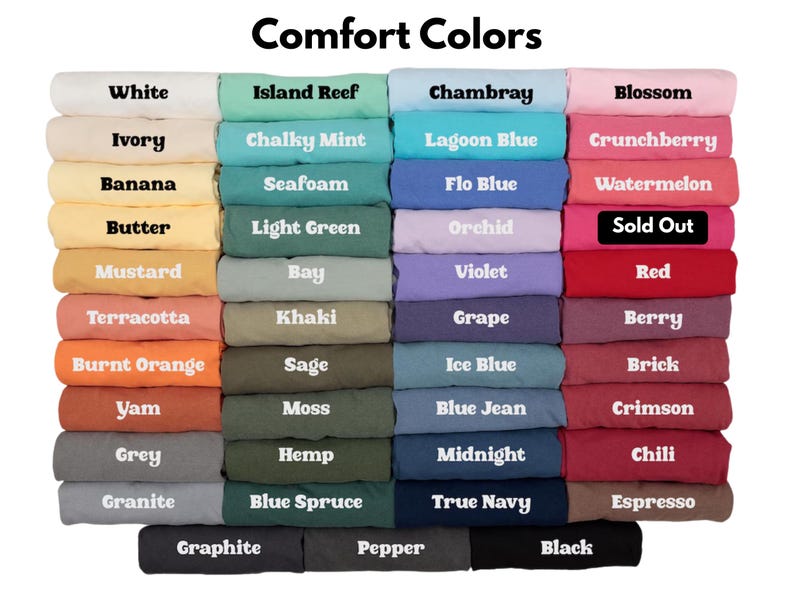 May include: A color chart titled Comfort Colors displaying a grid of folded t-shirts in various shades including white, ivory, banana, butter, mustard, terracotta, burnt orange, yam, grey, granite, island reef, chalky mint, seafoam, light green, bay, khaki, sage, moss, hemp, blue spruce, chambray, lagoon blue, flo blue, orchid, violet, grape, ice blue, blue jean, midnight, true navy, blossom, crunchberry, watermelon, red, berry, brick, crimson, chili, espresso, graphite, pepper, and black, with one label marked Sold Out.