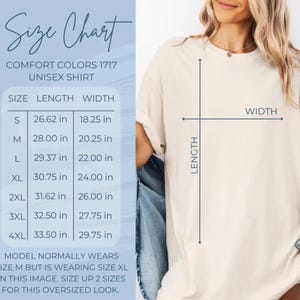May include: A beige Comfort Colors 1717 unisex t-shirt shown with a size chart. The chart lists lengths from 26.62 inches to 33.50 inches and widths from 18.25 inches to 29.75 inches. The text indicates the model is wearing a size XL for an oversized look.
