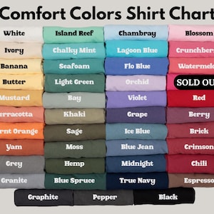 Puede incluir: Una carta de colores para camisetas Comfort Colors, que muestra una variedad de camisetas dobladas en varios colores. La carta incluye colores como blanco, island reef, chambray, blossom, y muchos m&aacute;s. El texto "SOLD OUT" es visible en una de las camisetas.