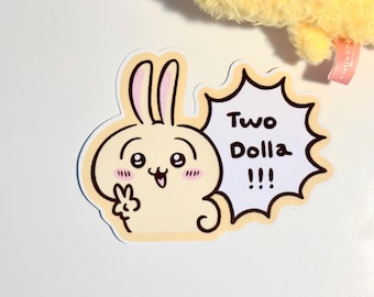 以下が含まれることがあります： ピンクの耳を持つ黄色い漫画のウサギで、吹き出しに「Two Dolla!!!」と書かれています。