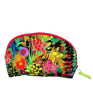May include: A black cosmetic bag with a vibrant floral pattern in shades of red, pink, yellow, and green. The bag has a red zipper and a lime green pull tab. The bag is a half-moon shape.